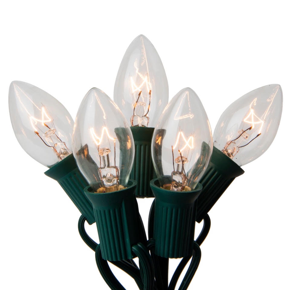 Christmas light strand detail Five clear Christmas light bulbs with green sockets and wire on a white background.